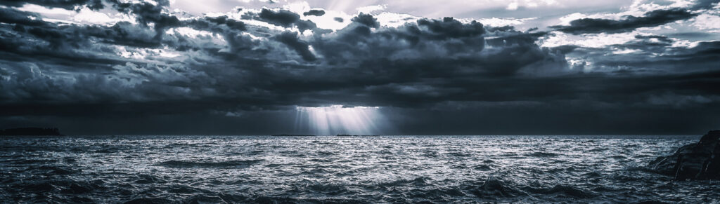 ToF Behang zon door donkere wolken boven zee