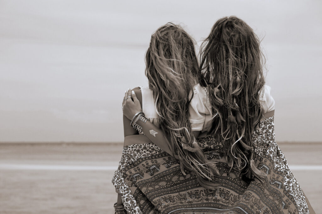 ToF Fotobehang bohemian twee mooie boho-meisjes die naar zee kijken