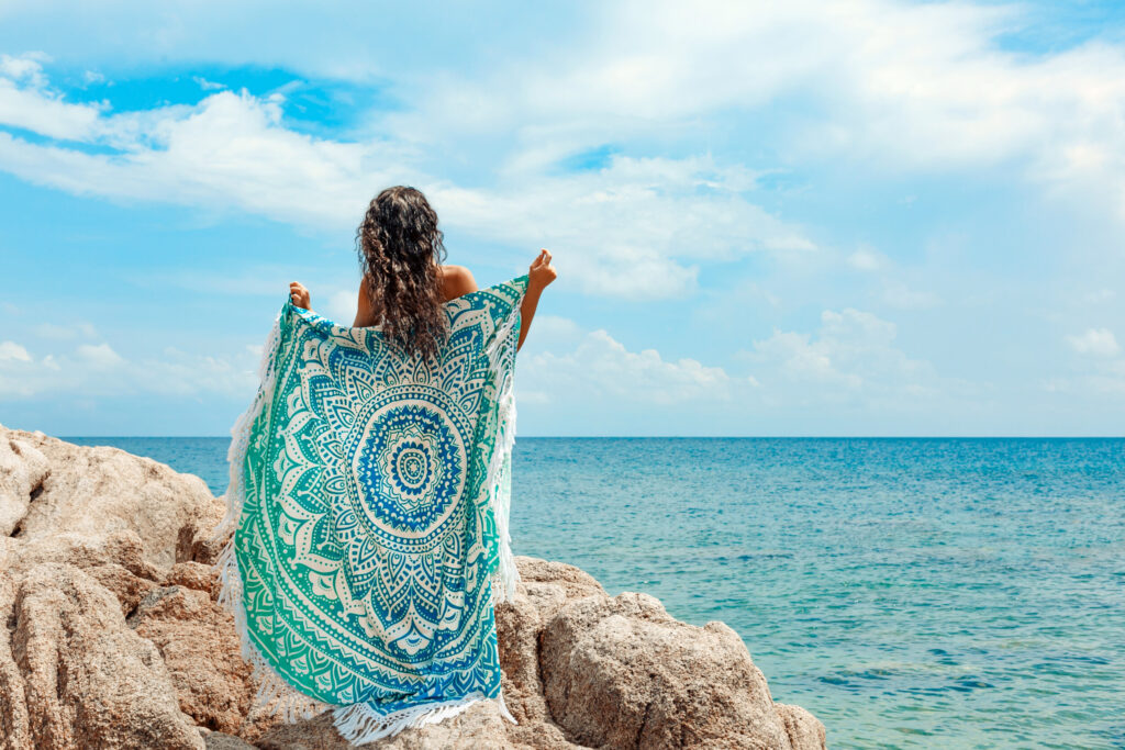 ToF Fotobehang bohemian jonge vrouw op strand met handdoek in bohemian stijl