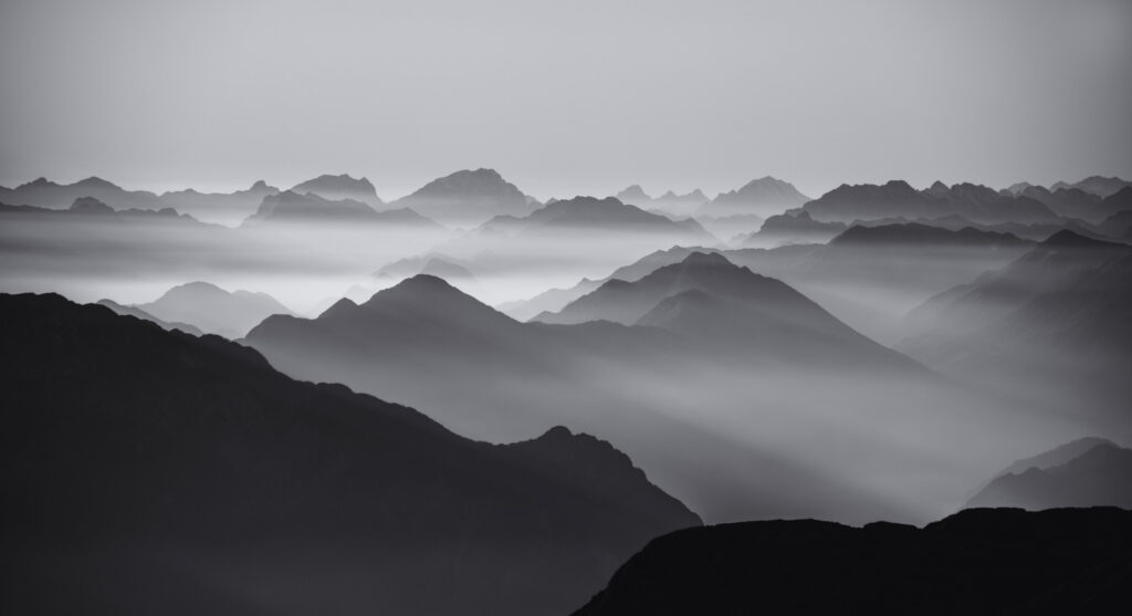 ToF Fotobehang zwart-wit silhouetten van bergen in de wolken